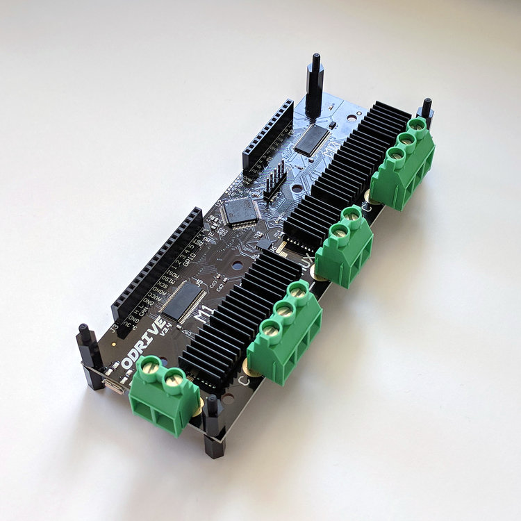 An image of a black circuit board with green screw terminals